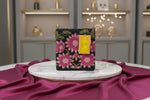 A pink floral handcrafted tote bag with glass bead embroidery on a dark base, displayed on a wooden surface.