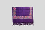 A purple pashmina scarf with floral embroidery and tassels on the ends, displayed on a white background.