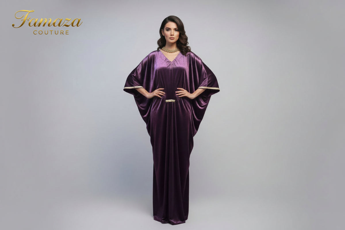 A purple velvet kaftan dress displayed on a mannequin, featuring a batwing sleeve design and a V-neckline.