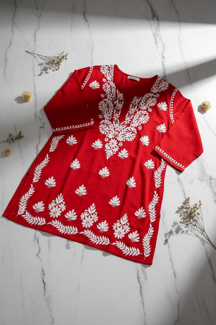 A red long-sleeve tunic dress with white floral and leaf embroidery, shown against a plain white background.