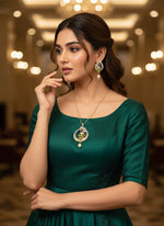 A rhodium-gold plated brass pendant with a peacock design accompanied by earrings, featuring vibrant green, blue, and gold enamel accents, as well as sparkling white AD stones embellishments.