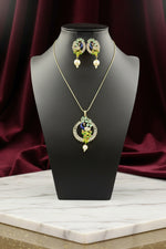 A rhodium-gold plated brass pendant with a peacock design accompanied by earrings, featuring vibrant green, blue, and gold enamel accents, as well as white and turquoise AD stones sparkling embellishments.