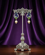 A rhodium-silver plated peacock design accompanied earrings, featuring vibrant green, blue and yellow enamel accents, as well as sparkling white and blue AD crystal stones. Earrings design is focused. 