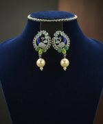 A rhodium-silver plated peacock design accompanied earrings, featuring vibrant green, blue and yellow enamel accents, as well as sparkling white andturquoise crystal stones. Earrings design is focused. 