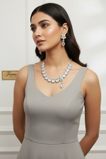 A set of American diamond jewellery consisting of a necklace and earrings with 3D floral elements, featuring ad white stones.