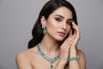 A set of American diamond jewellery consisting of a necklace and earrings with 3D floral elements, featuring turquoise and white stones.