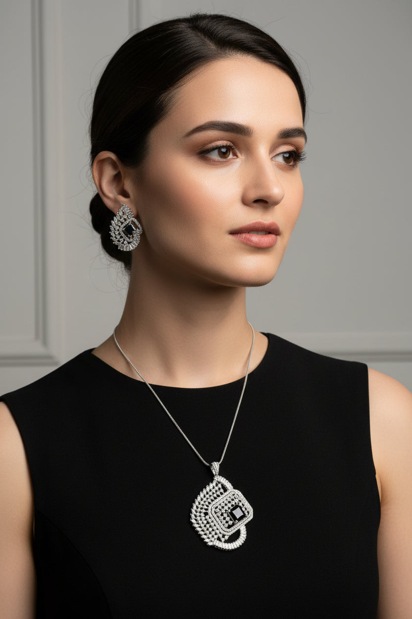 A set of artificial AD pendant and earrings with black centre stone, featuring a geometric design with intricate detailing, displayed on a mannequin.