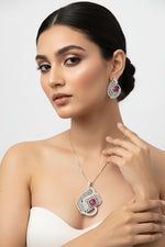 A set of artificial AD pendant and earrings with ruby pink centre stone, featuring a geometric design with intricate detailing, displayed on a mannequin.