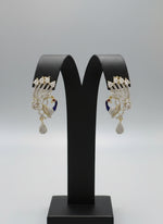 A set of peacock-shaped earrings. The earrings are detailed with blue enamel and has sparkling white and AD stones crystal embellishments. Party wear Earrings. Earrings are in focused.