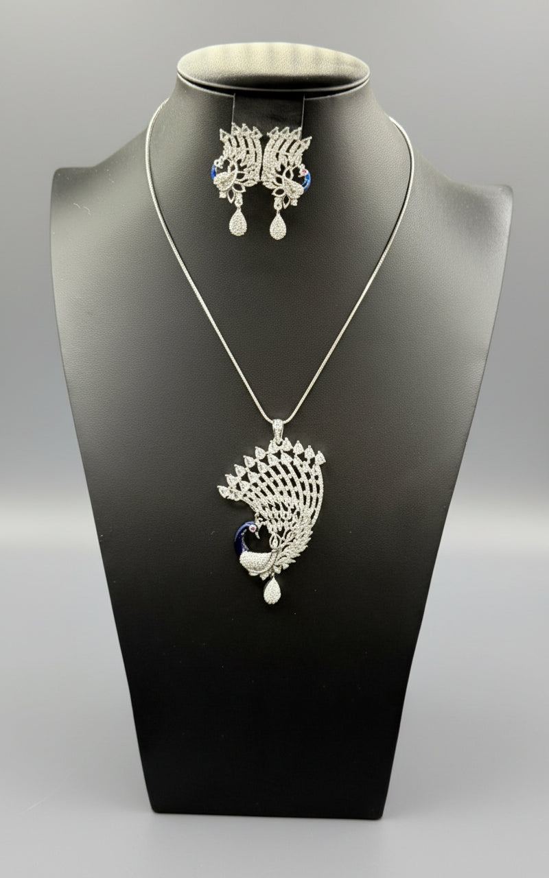 A set of peacock-shaped pendant and earrings. The pendant is detailed with blue enamel and has white ad sparkling crystal embellishments.