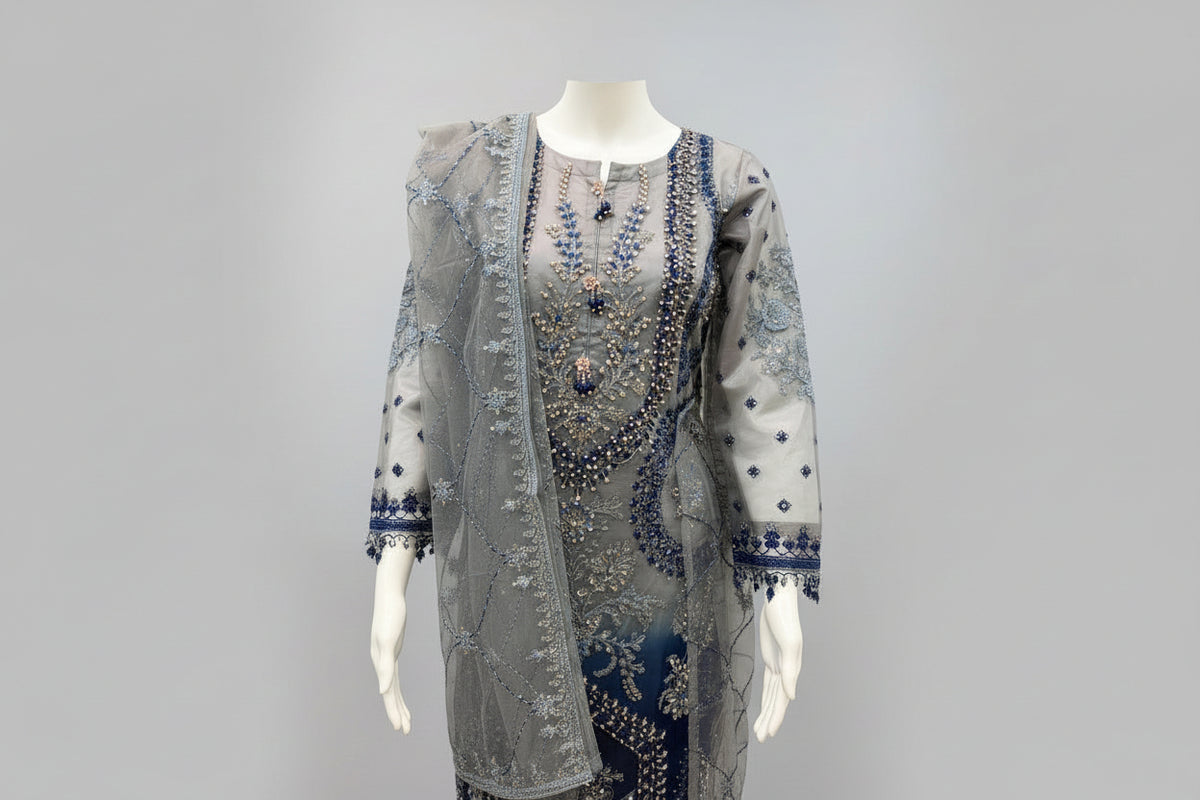 A side view and showing sleeves work of Net fabric in grey and navy blue two tone 3pcs Pakistani dress with hand embellishments on all over kurti and dupatta with plain grey silk straight trousers 