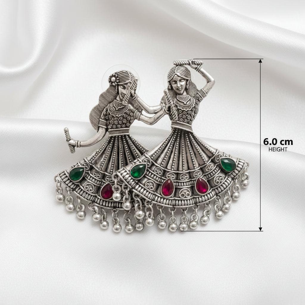 A silver-toned decorative wall plaque depicting two traditional dancing women, shown on a white background with a dimension marker indicating a height of 6.0 cm.