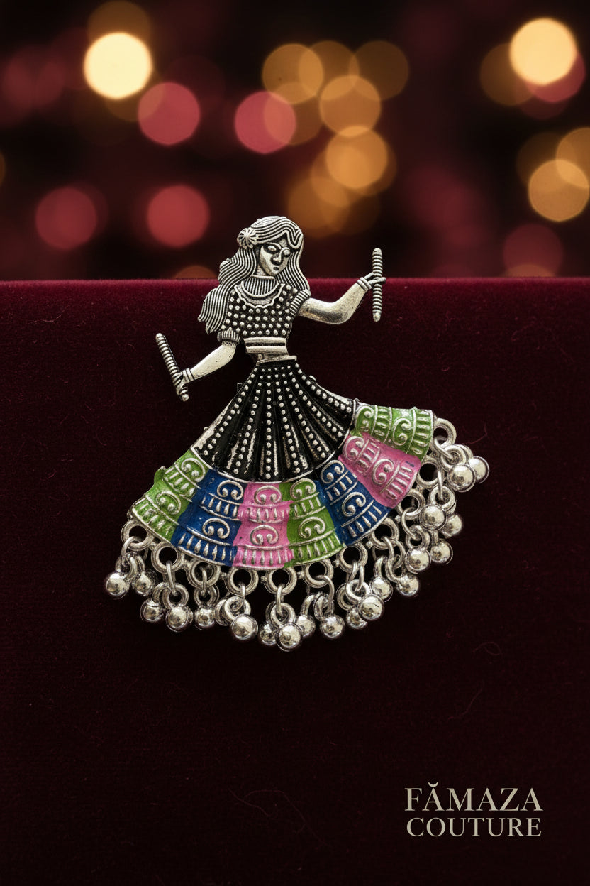 A silver tone meta oxidised earring design is showing a woman is playing dandiya in navratri lehnga choli traditional dress for navratri. 