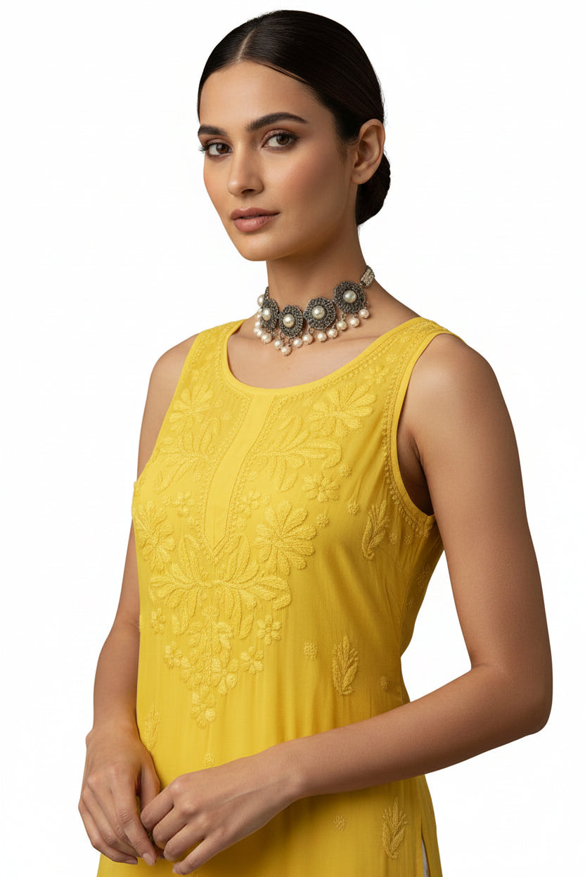 A sleeveless bright yellow embroidered kurta dress displayed on a white mannequin, paired with a cream-colored lace skirt, set in a store doorway with yellow flooring.