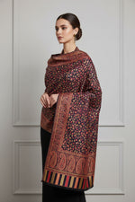 A vibrant Kashmiri party wear Kani scarf with a floral paisley pattern and border stripes in a red and multicolour design.