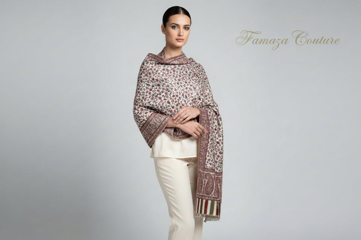 A white based Kashmiri party wear Kani scarf featuring a floral paisley pattern with border stripes, predominantly in red and white colours by Famaza Couture .