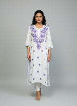 A white long kurti with purple coloured embroidery 