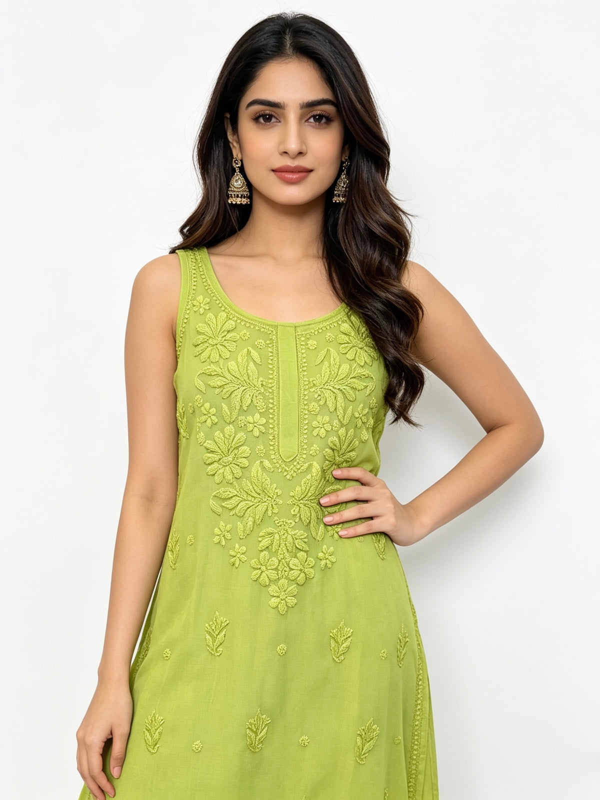 A woman modelling a sleeveless lime green kurta with detailed floral embroidery on the bodice, set against a plain white studio background.