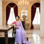A woman posing in a purple colour Georgette Saree with chikankari Keel Jaal Embroidery and Resham Work, with a hot pink blouse piece and traditional Indian jewellery.