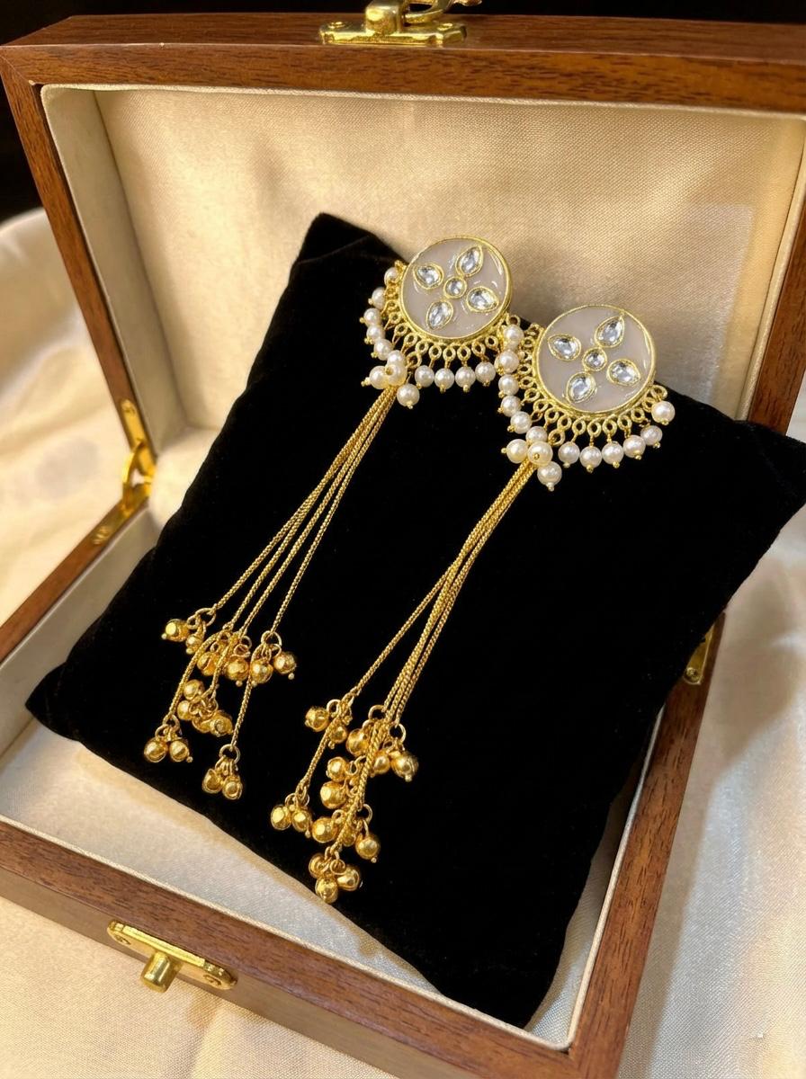 All-white crystal-encrusted filigree jhumka earrings with clear pear-cut studs and shimmering crystal fringe.