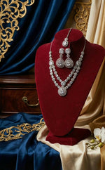 American Diamond necklace , earrings and maag tikka with cubic zirconia stones displayed on a velvet stand with ornate background
