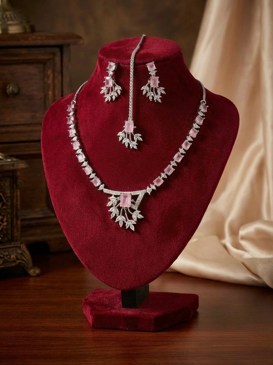 American diamond jewellery set including necklace, earrings and maang tikka with pink centre stone. 