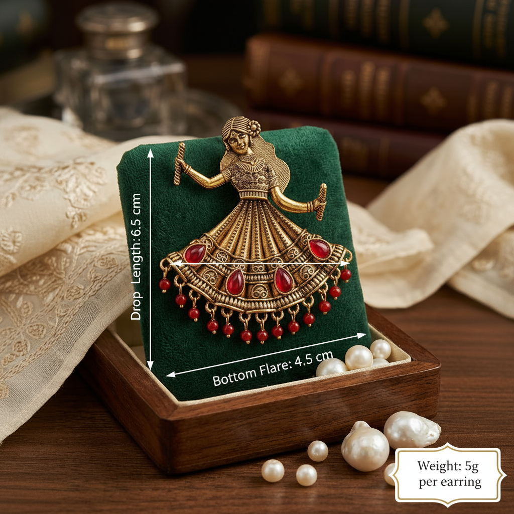 A gold-toned Indian-style bridal jewelry piece featuring a dancing woman motif and red stone embellishments, displayed on a green velvet jewelry box. The box sits on a wooden surface with pearls and books in the background.