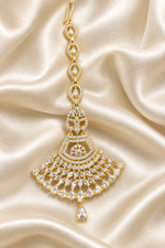 Anfal gold plated fan‑shaped American Diamond maang tikka laid flat on cream ivory silk satin — Famaza Couture premium gold bridal forehead jewelry.