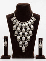 Antique silver Y-shaped statement choker necklace set with mirror accents and matching jhumka dangle earrings, displayed on brown velvet bust.