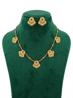 Antique gold brass metal necklace and stud earrings with emerald green central stones. 