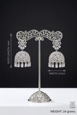 Silver-toned double earring set on a metal display stand against a black background, with measurement annotations showing drop length 4 cm, width 2.5 cm, and weight 24 grams.