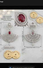 Luxury Aria Chaand Bali statement earrings with a vibrant red oval centerpiece and detailed diamond-cut accents. Product infograph highlights a 7.5 cm drop length, 5.5 cm width, a total weight of 16 grams, and features interchangeable back stoppers including butterfly, plastic safety, and screw-back options.