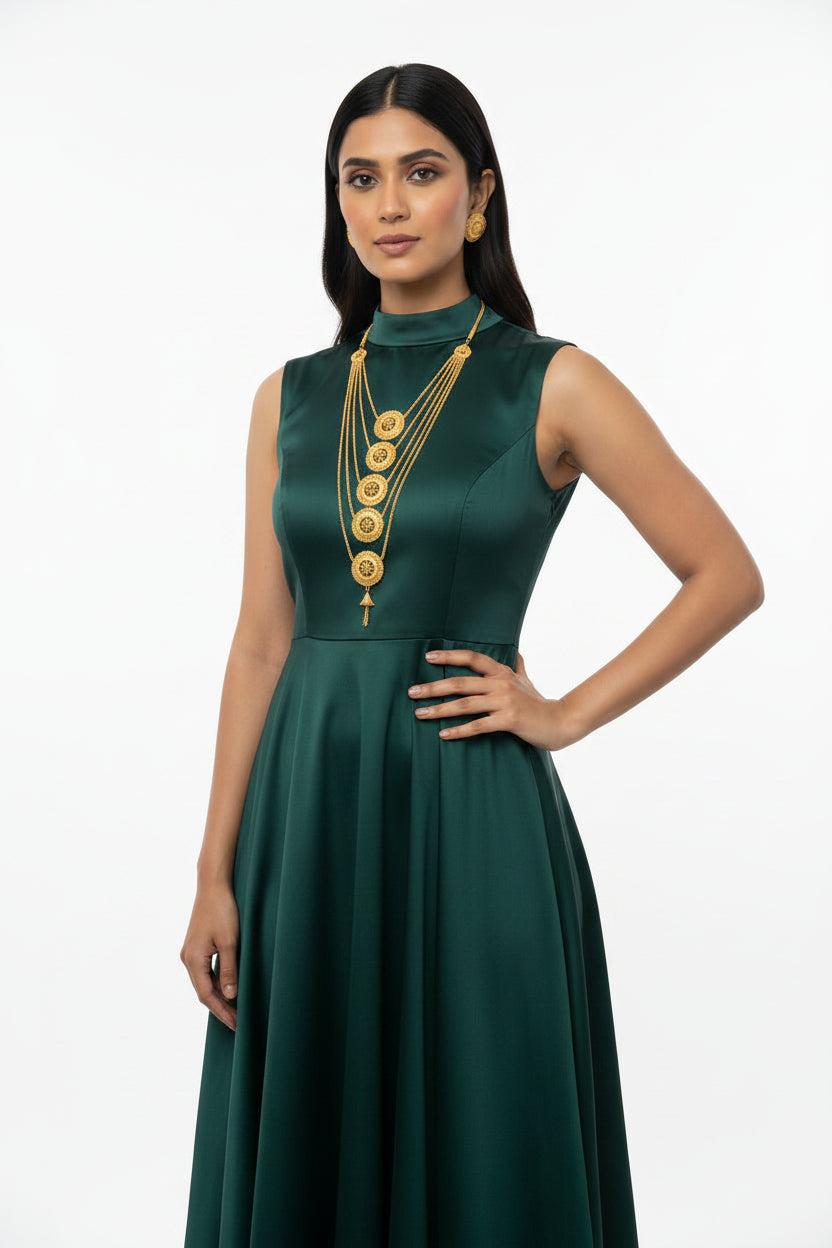 A model wearing the Ayesha Splendor gold-plated multi-layered necklace set with matching stud earrings by Famaza Couture, captured in a forward-facing pose against a pure white background.