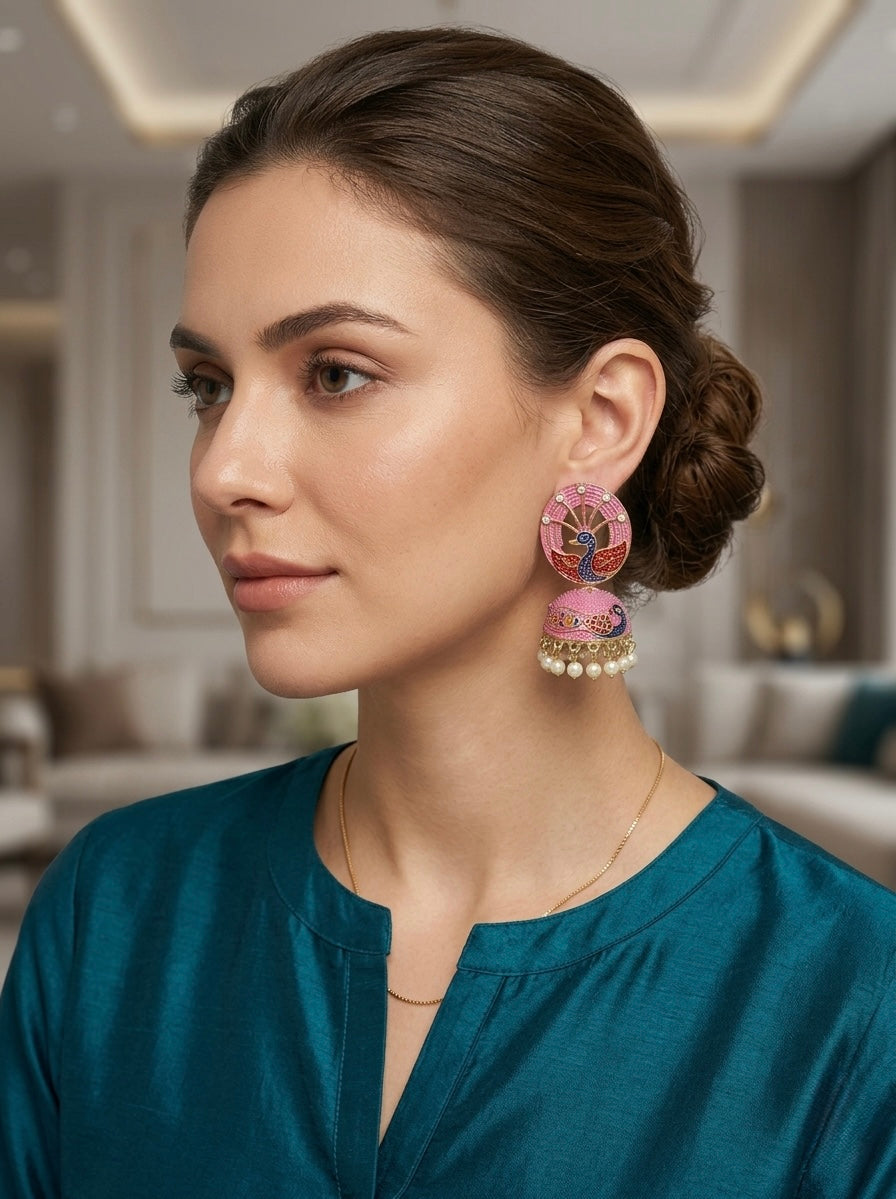 Woman wearing pink jhumka earrings in a blurred indoor setting