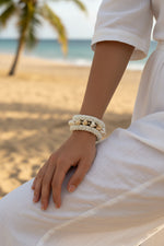 Beaded bracelet with shell accents on a textured surface