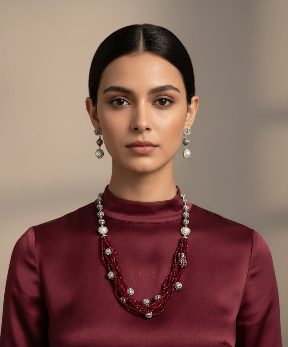 Beaded mala with silver and pearl beads in on both sides start and drop is designed with maroon colour nano glass bead with silver ball beads, along withLotus design earrings with silver and pearl beads in drop. Oxidised party wear jewellery set. 