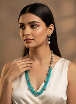 Beaded mala with silver and pearl beads in on both sides start and drop is designed with sky blue colour glass nano bead and silver ball beads, along withLotus design earrings with silver and pearl beads in drop. Oxidised party wear jewellery set. 