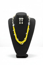 Beaded mala with silver and pearl beads in on both sides start and drop is designed with yellow nano glass bead with silver ball beads, along withLotus design earrings with silver and pearl beads in drop. Oxidised jewellery set. 