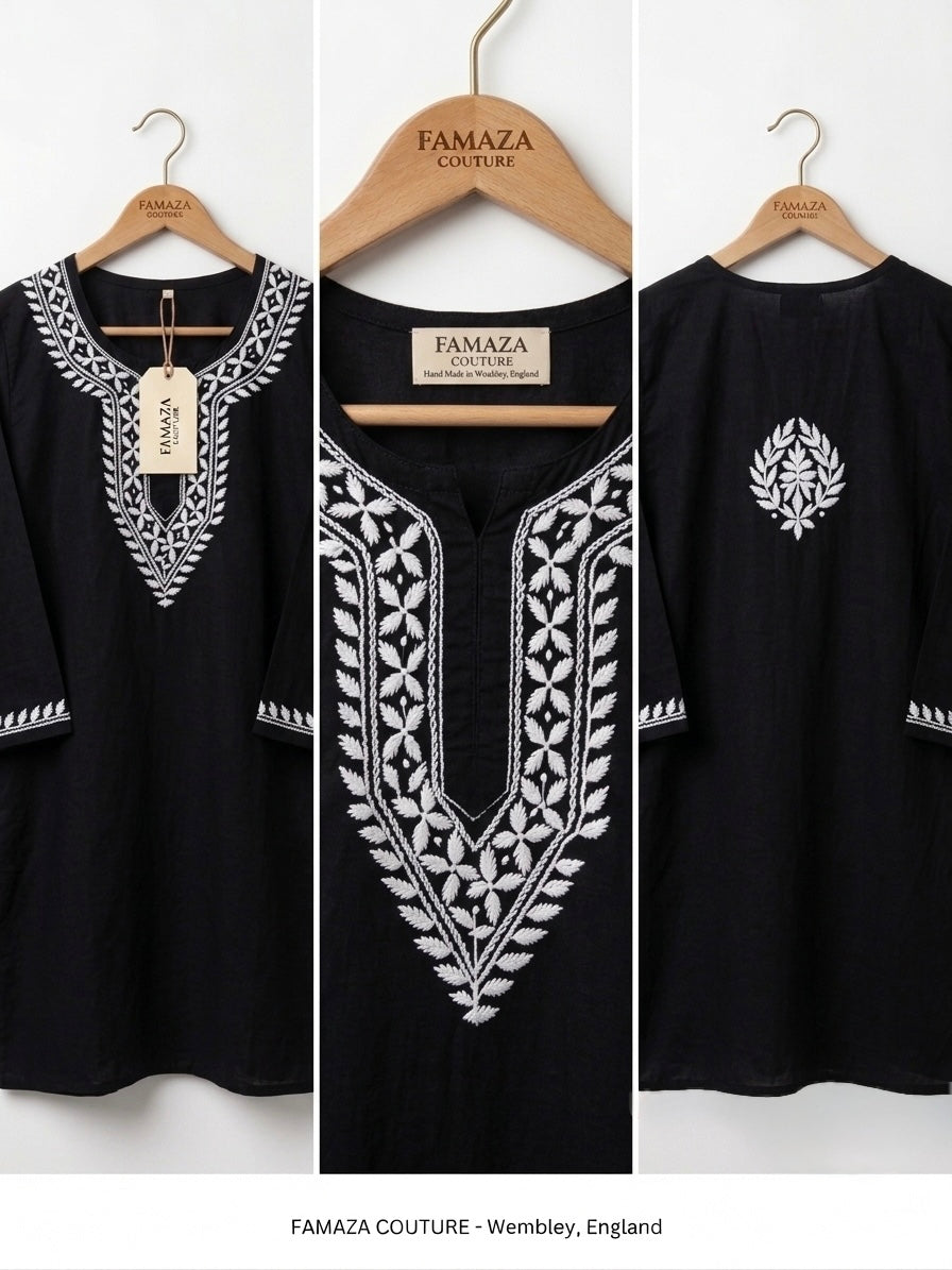Black cotton tunic top with white embroidered patterns, shown from front and back on wooden hangers against a white background. The brand name FAMAZA COUTURE is visible on the hangers and hangtag.