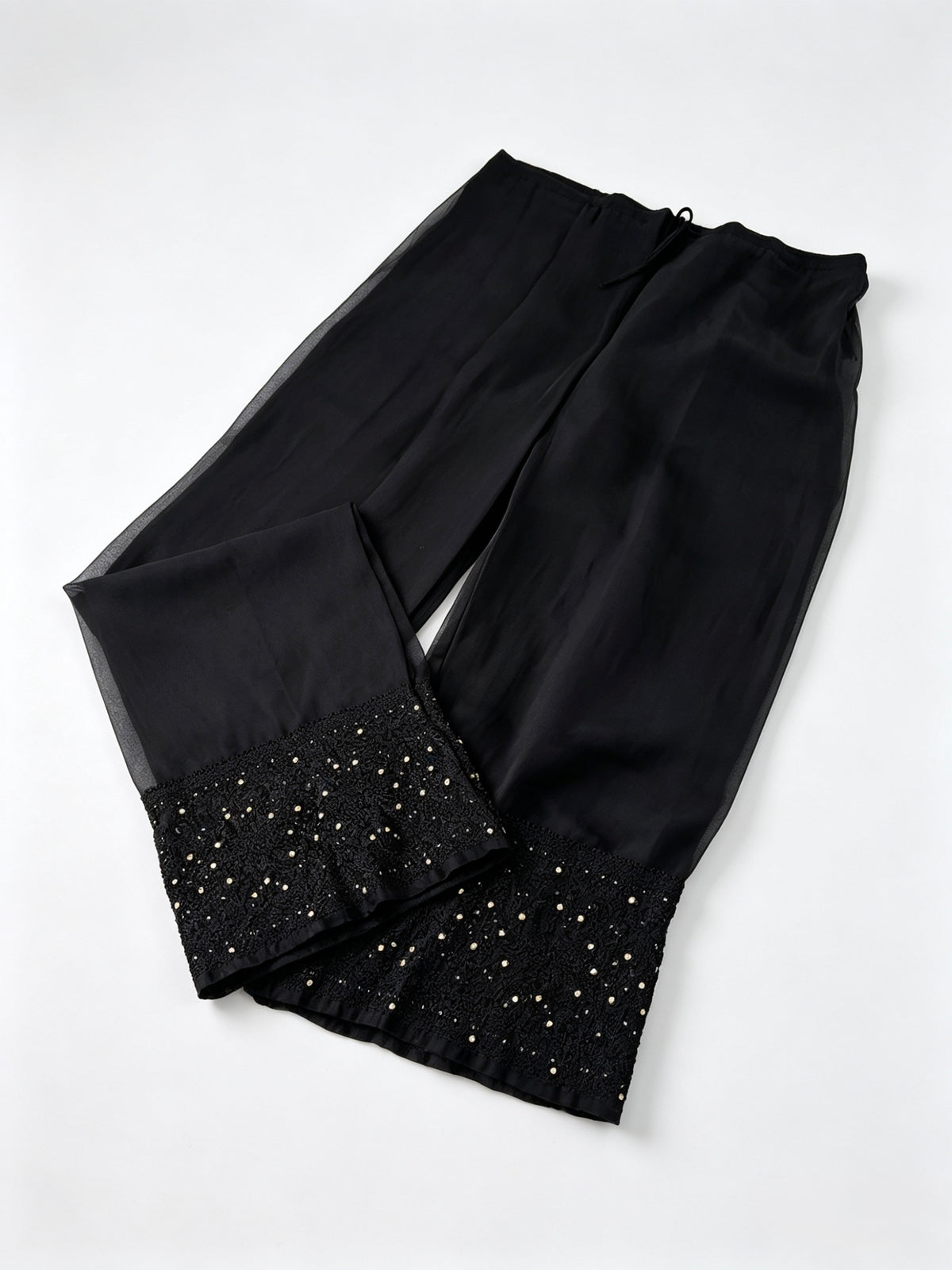 Black georgette pants with black thread hand embroidery and antique gold kaamdani work. 