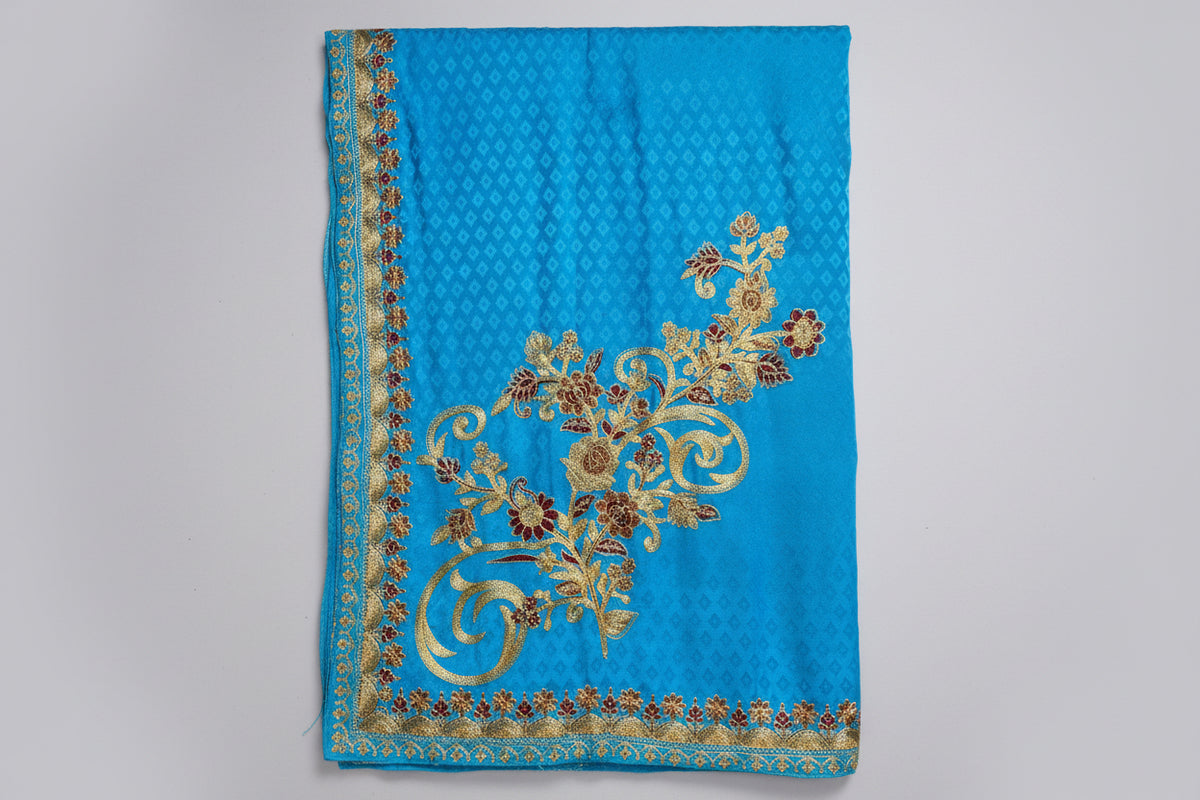 Blue fabric with gold embroidery on a gray background