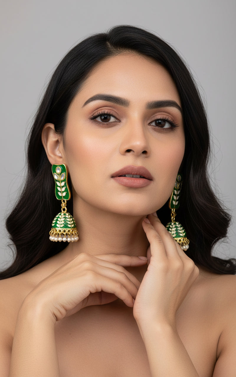 Bottle Green colour pair of gold-platedMeenakari drop Jhumka earrings displayed on a stand, featuring intricate designs and studded with stones.