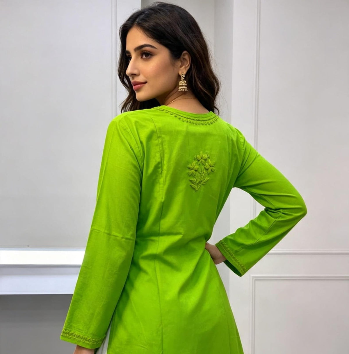 Rear view of a woman wearing a vibrant lime green cotton short kurti featuring a delicate floral motif embroidered on the back yoke, designed with a square hem line.