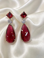 Close-up detail of ruby stone and high-shine cubic zirconia CZ detailing on rhodium plated earrings