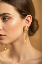 Close-up of 4cm rose gold finish earrings featuring a peacock motif with white stones and a ruby-red eye.