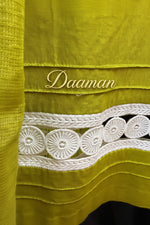 Close-up of a Olive green kurti bottom hem is adorned with white lace is shown in focus. 