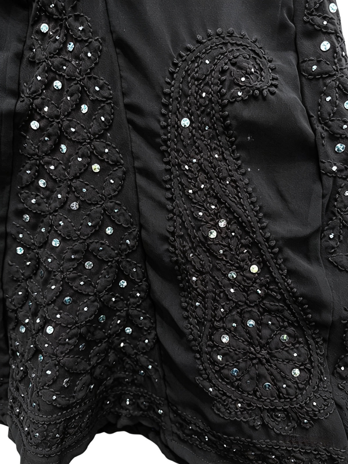 Close-up of a black garment with intricate beadwork and embroidery.