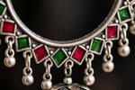 Close-up of the engraved round stud on a silver-tone hoop jhumka earring