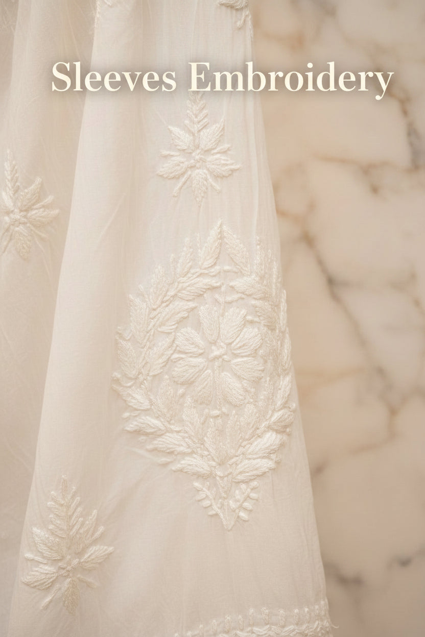 Close-up of a white embroidered sleeve with floral patterns.