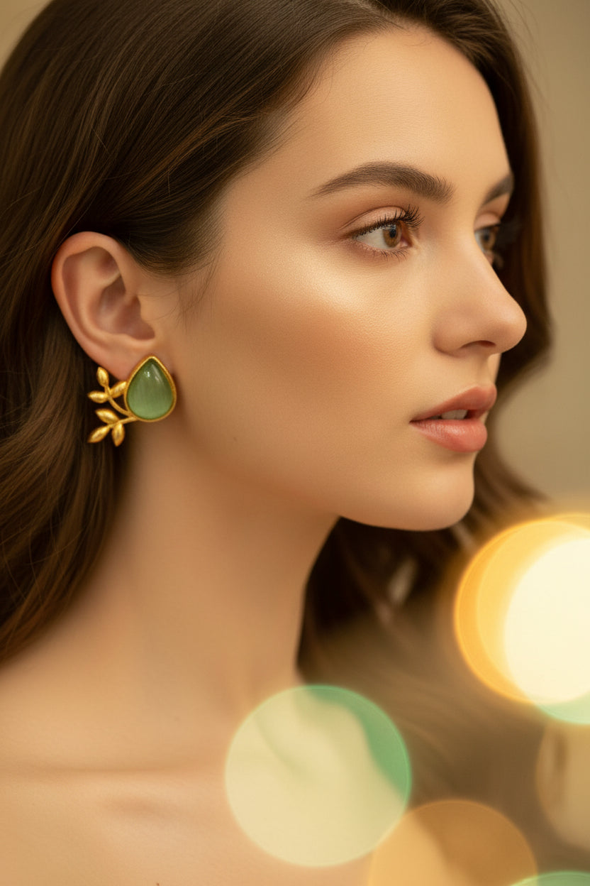 Close-up of a woman wearing a Sea green stone and gold earring 
